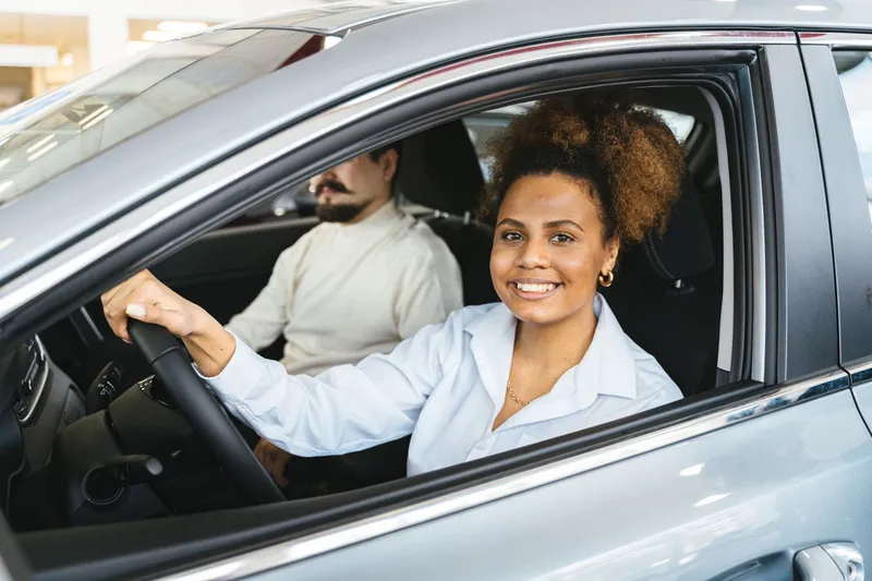 Mulher sorrindo ao volante do carro