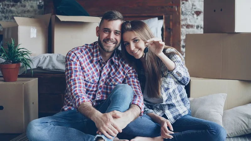 Casal sorrindo com as chaves da casa nova